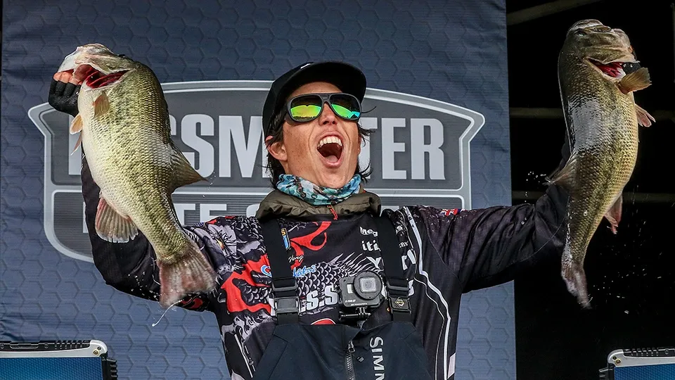 Matty Wong holding two largemouth bass at a Bassmaster tournament